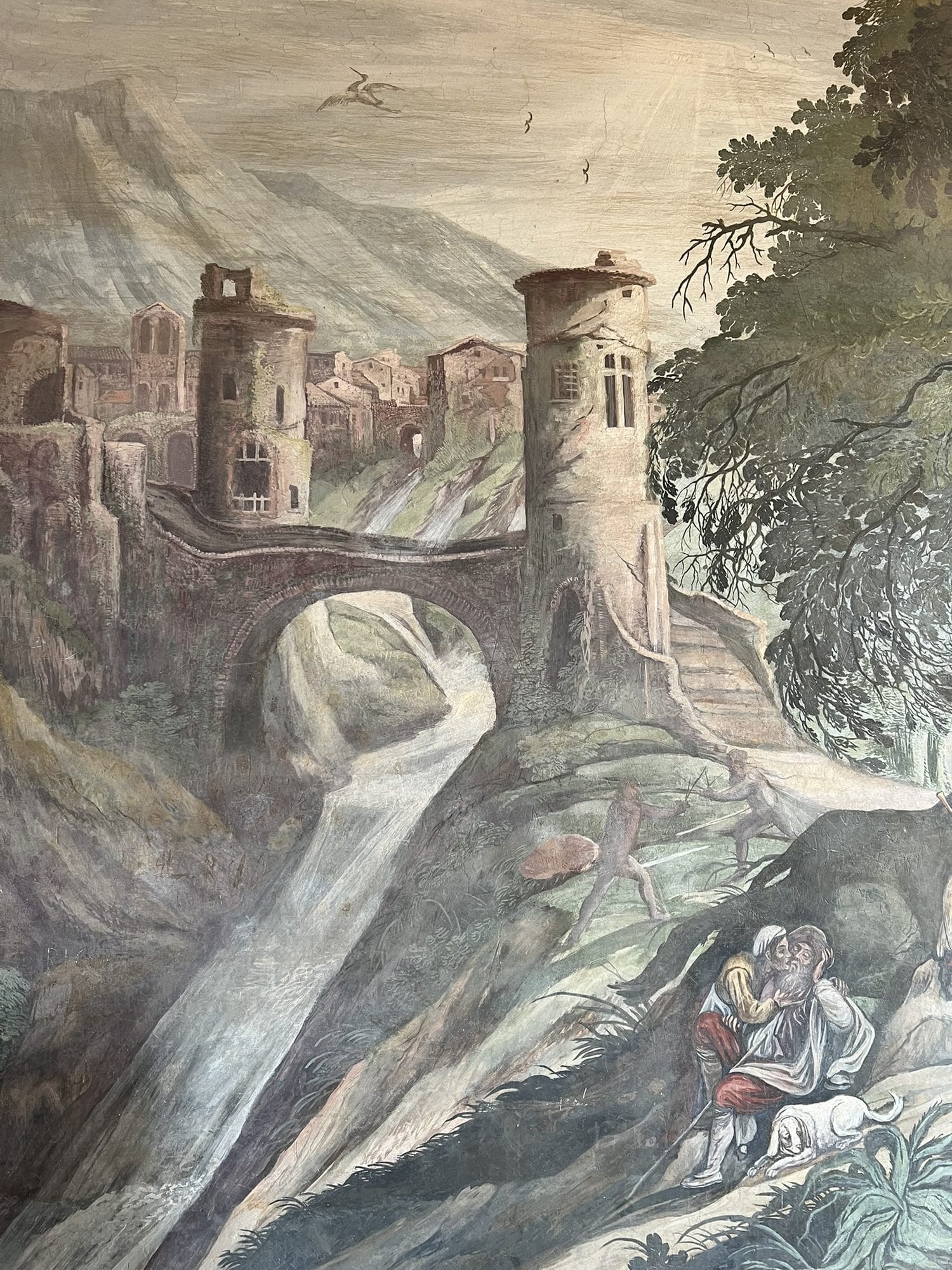 Frescoed landscape with a towered village, an arched bridge over a waterfall and two figures in the foreground