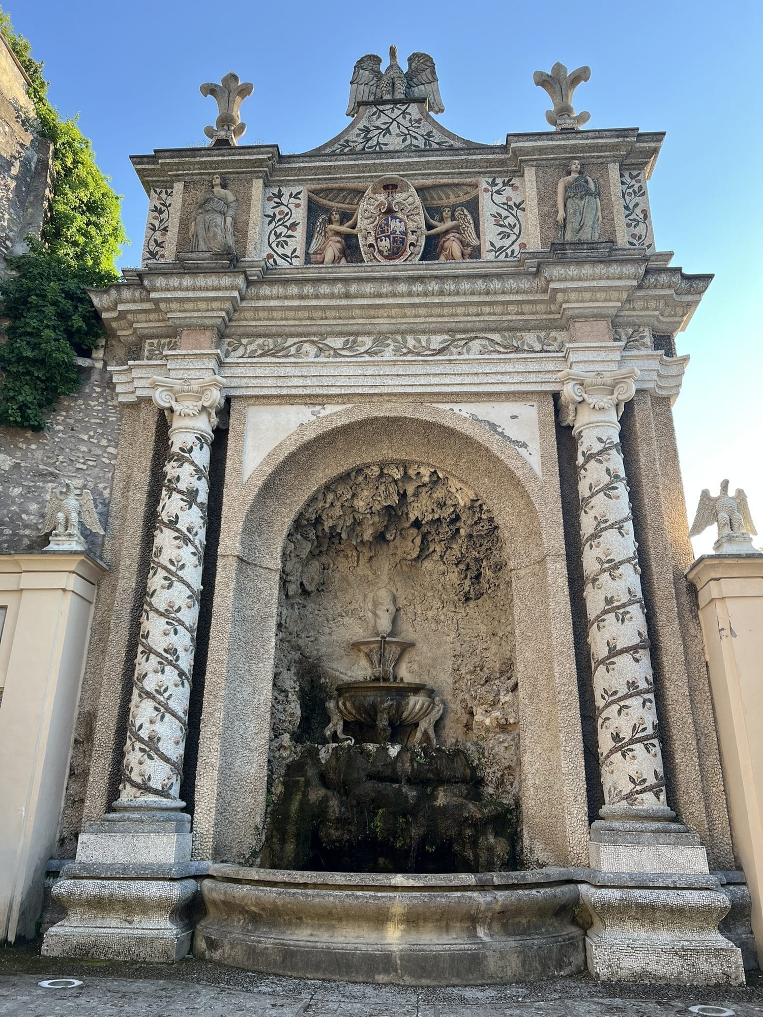 Stone aedicule with mosaic-decorated pilasters, Este eagles on top and a tiered fountain in the niche