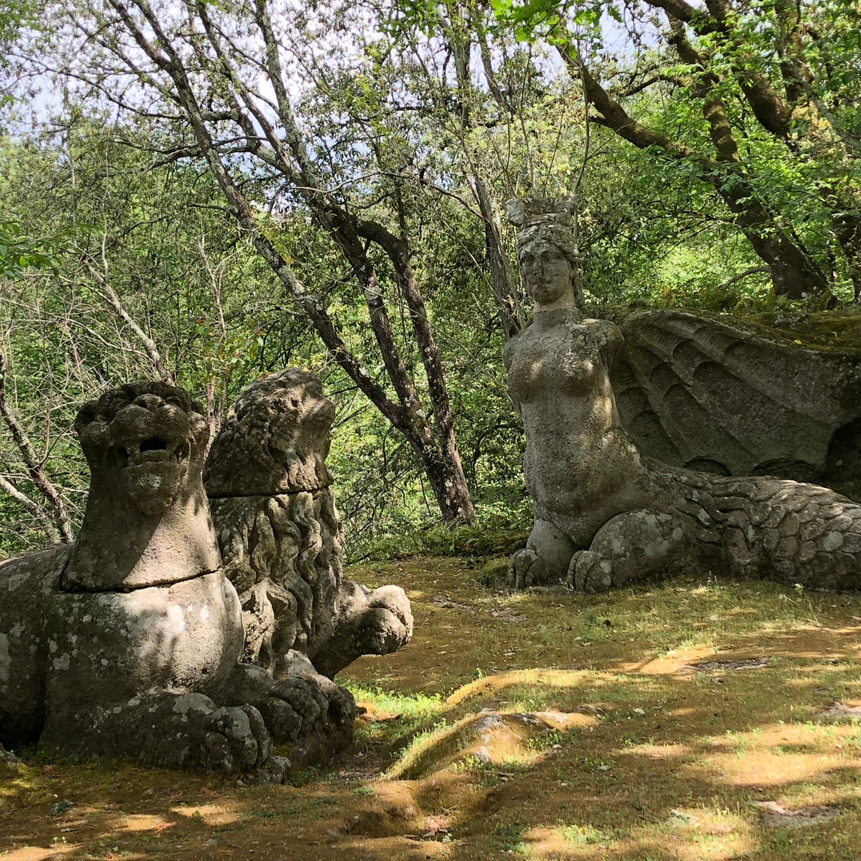Stone sculpture of the winged Fury with a woman's torso and dragon tail in the Sacro Bosco of Bomarzo.