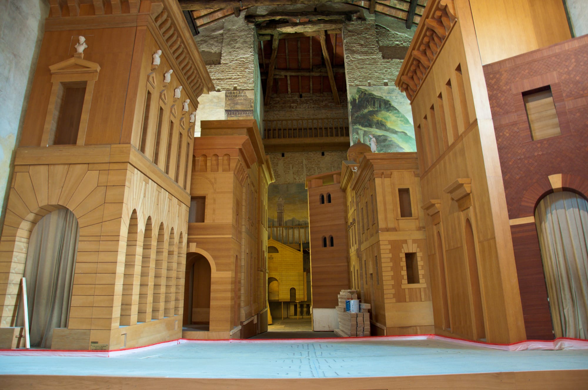 Wooden stage set of Renaissance palaces and a tower in false perspective, with a painted backdrop of a church at the end of the street, Teatro all'Antica, Sabbioneta