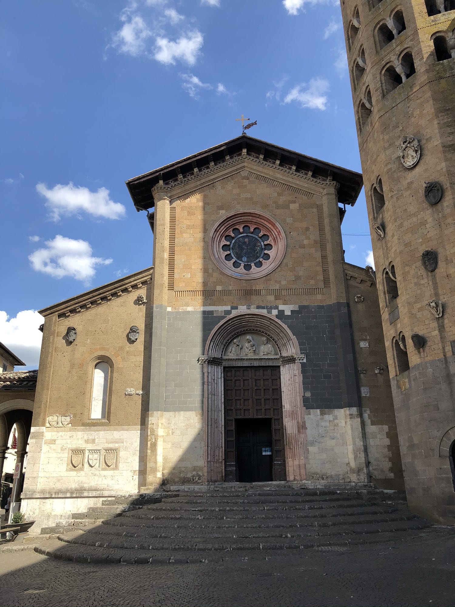 The front of the church of Sant'Andrea in Piazza della Repubblica, Orvieto, with its twelve-sided bell tower at the right edge