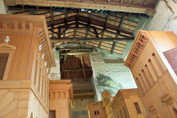 Wooden stage set of Renaissance palaces and a brick tower in false perspective, leading to a painted church at the end of the street, inside the Teatro all’Antica in Sabbioneta
