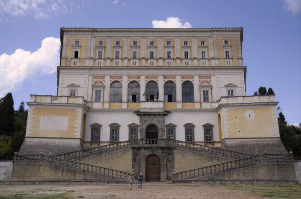 Front view of Villa Farnese at Caprarola from the lower square, with the double ramp of stairs, the terraces and the five-arched loggia under a blue sky