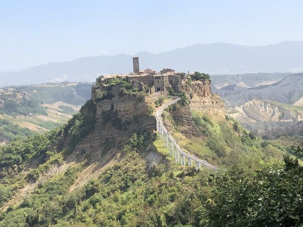 Civita di Bagnoregio seen from the belvedere in summer: the village on its tufa plateau above the calanchi, with the footbridge
