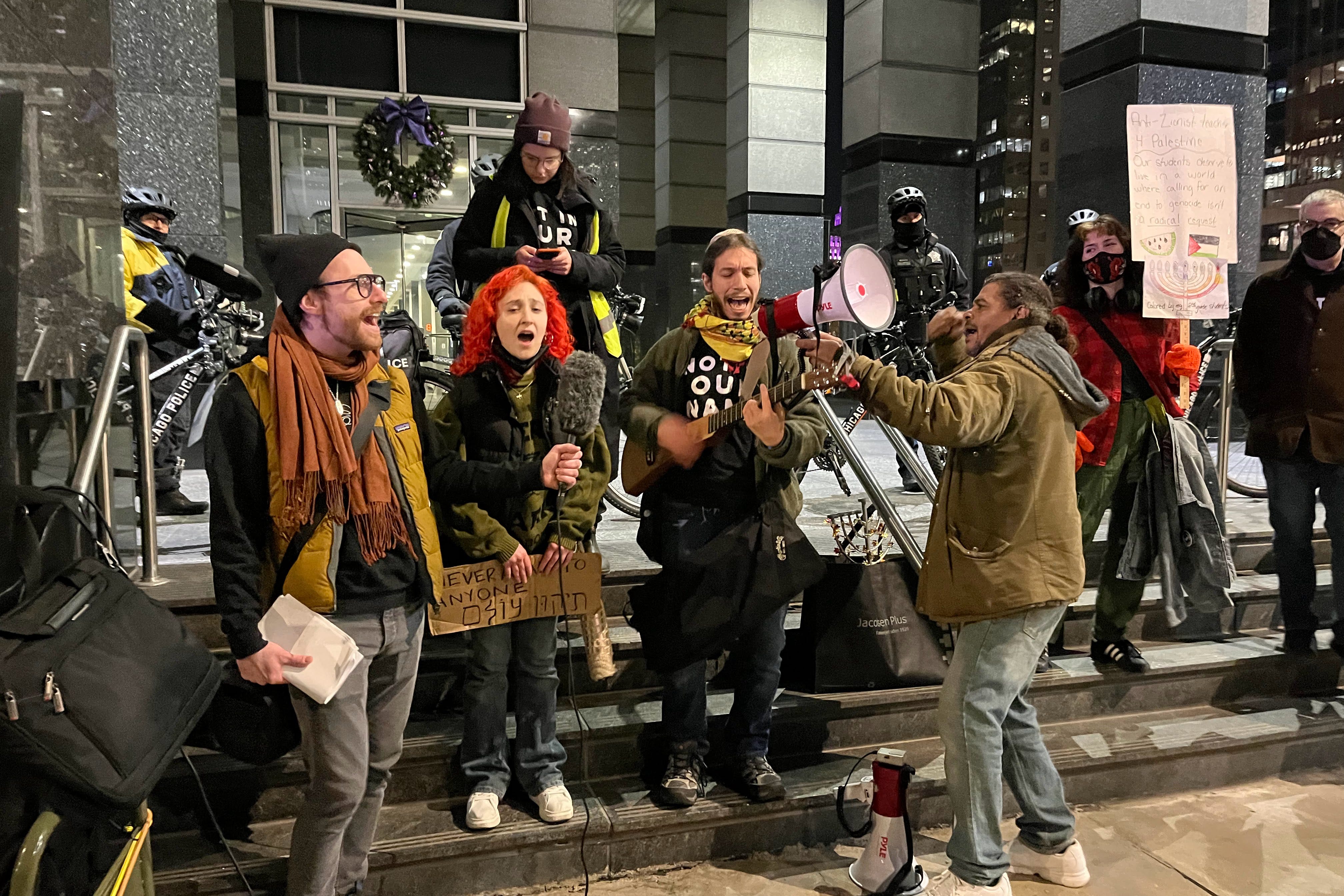 Protesters sing while one plays a stringed instrument outside the Boeing building in Chicago.