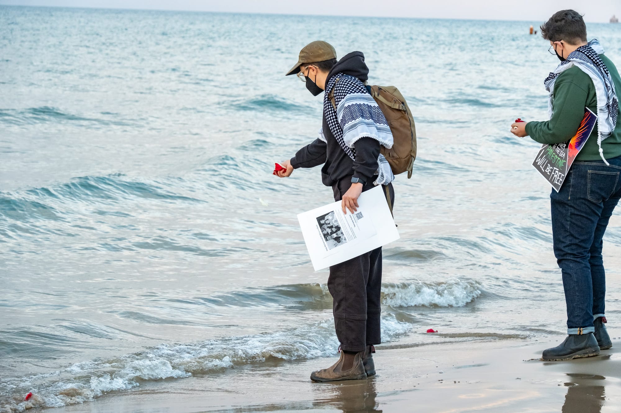 A mourner tosses rose petals into Lake Michigan.