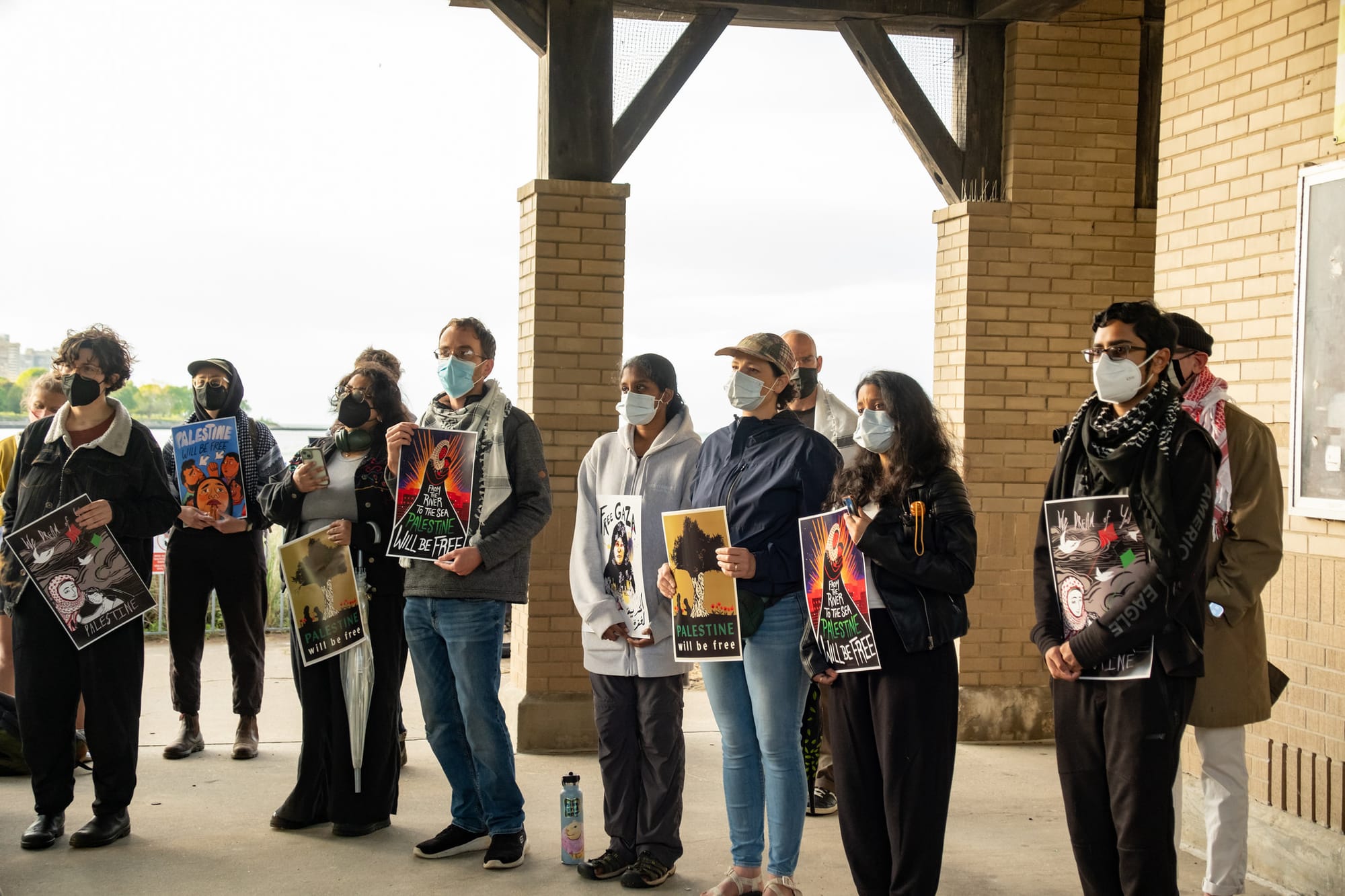 Protesters hold Palestine solidarity artwork.