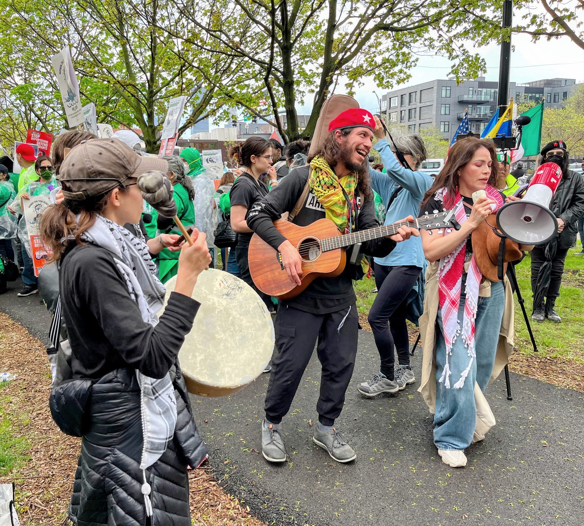 Protesters play musical instruments while a person sings through a bullhorn.