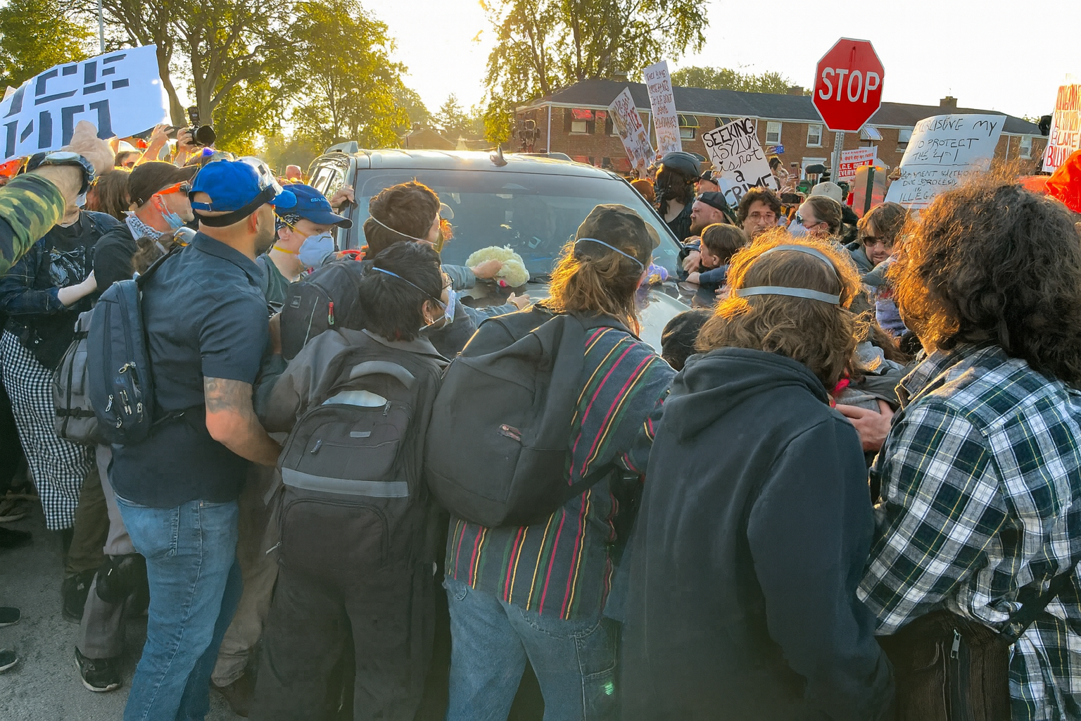 Protesters attempt to block the passage of an ICE vehicle.
