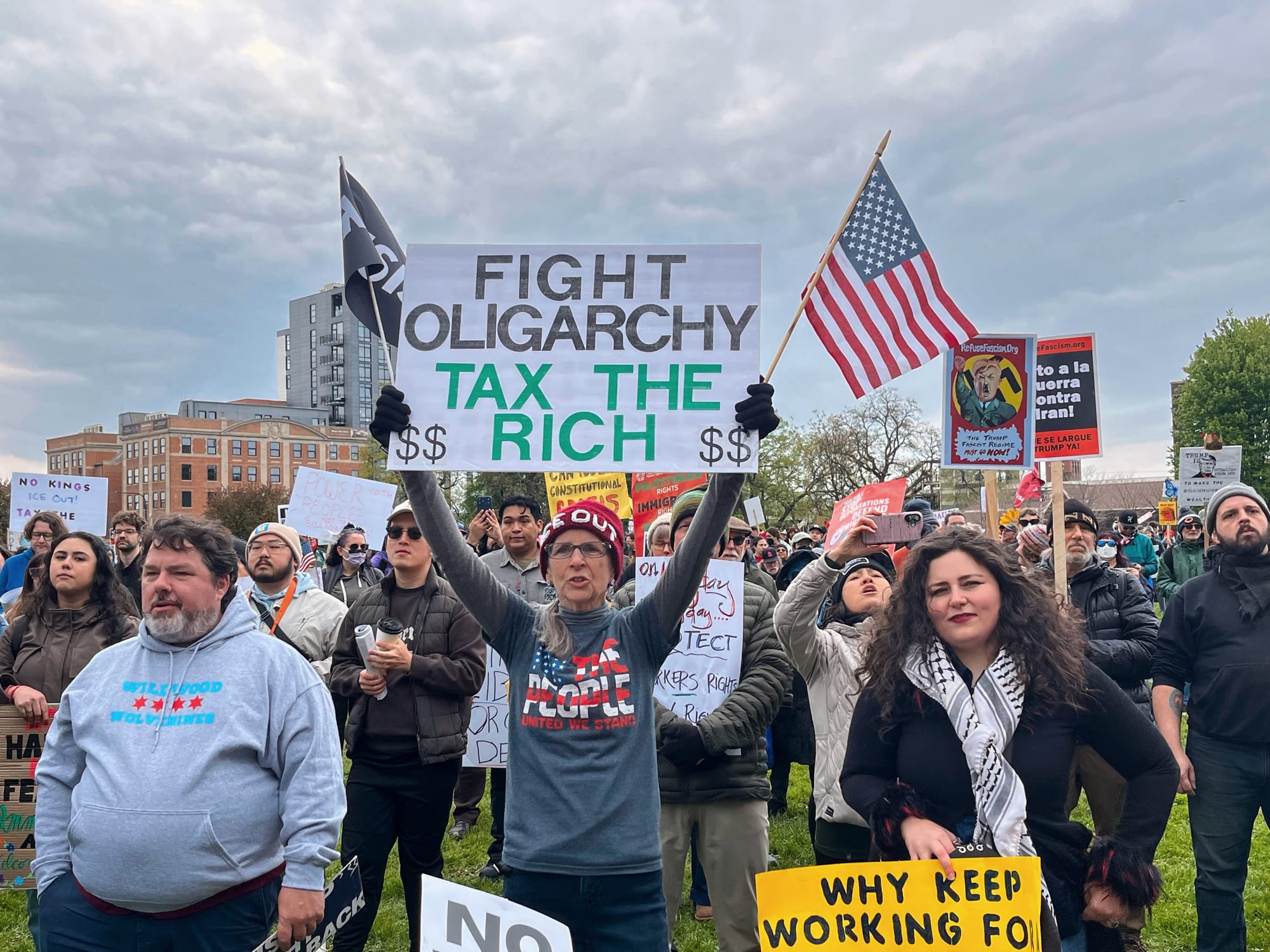 Protester holds a sign that says, "Fight oligarchy, tax the rich."