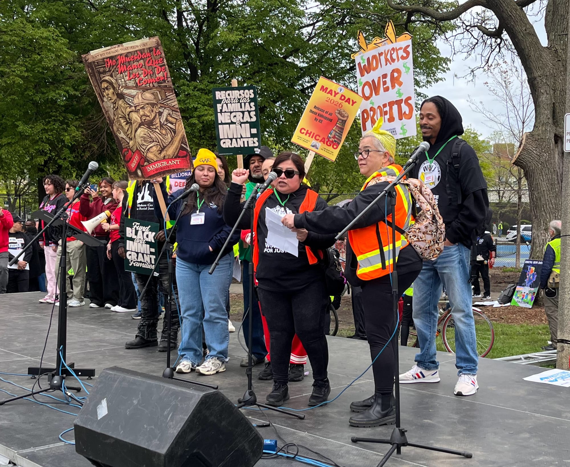 Warehouse workers for Justice speak at a rally on stage at a May Day rally.