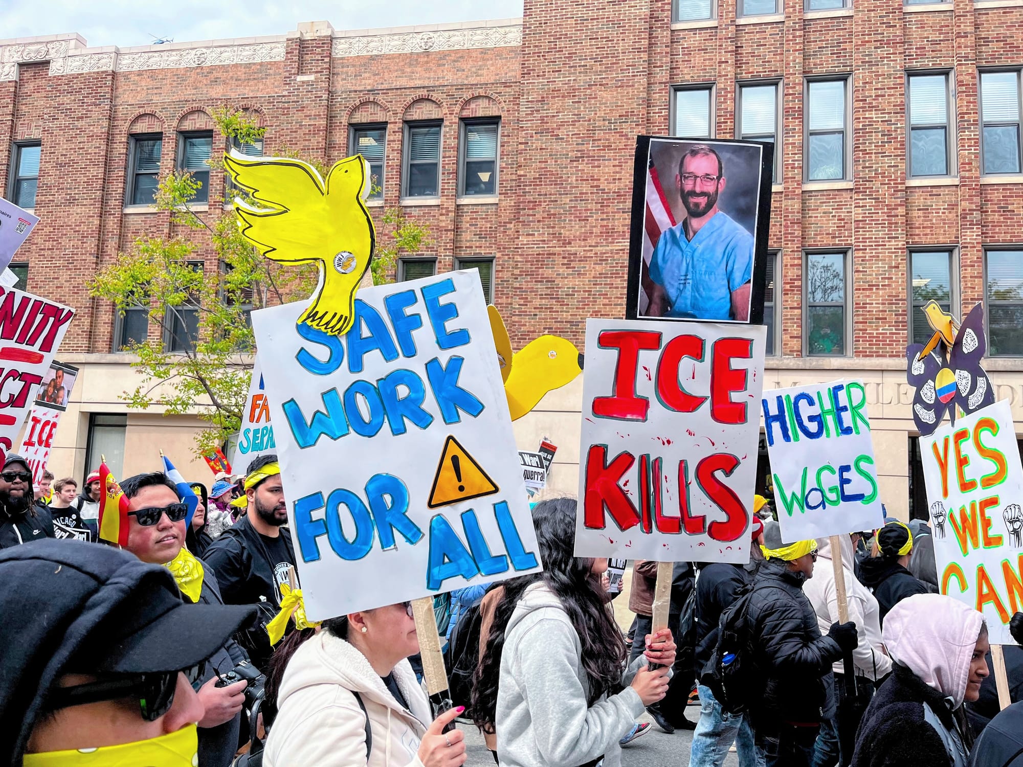 Protesters carry signs demanding safe work and denouncing ICE for killing Alex Pretti.