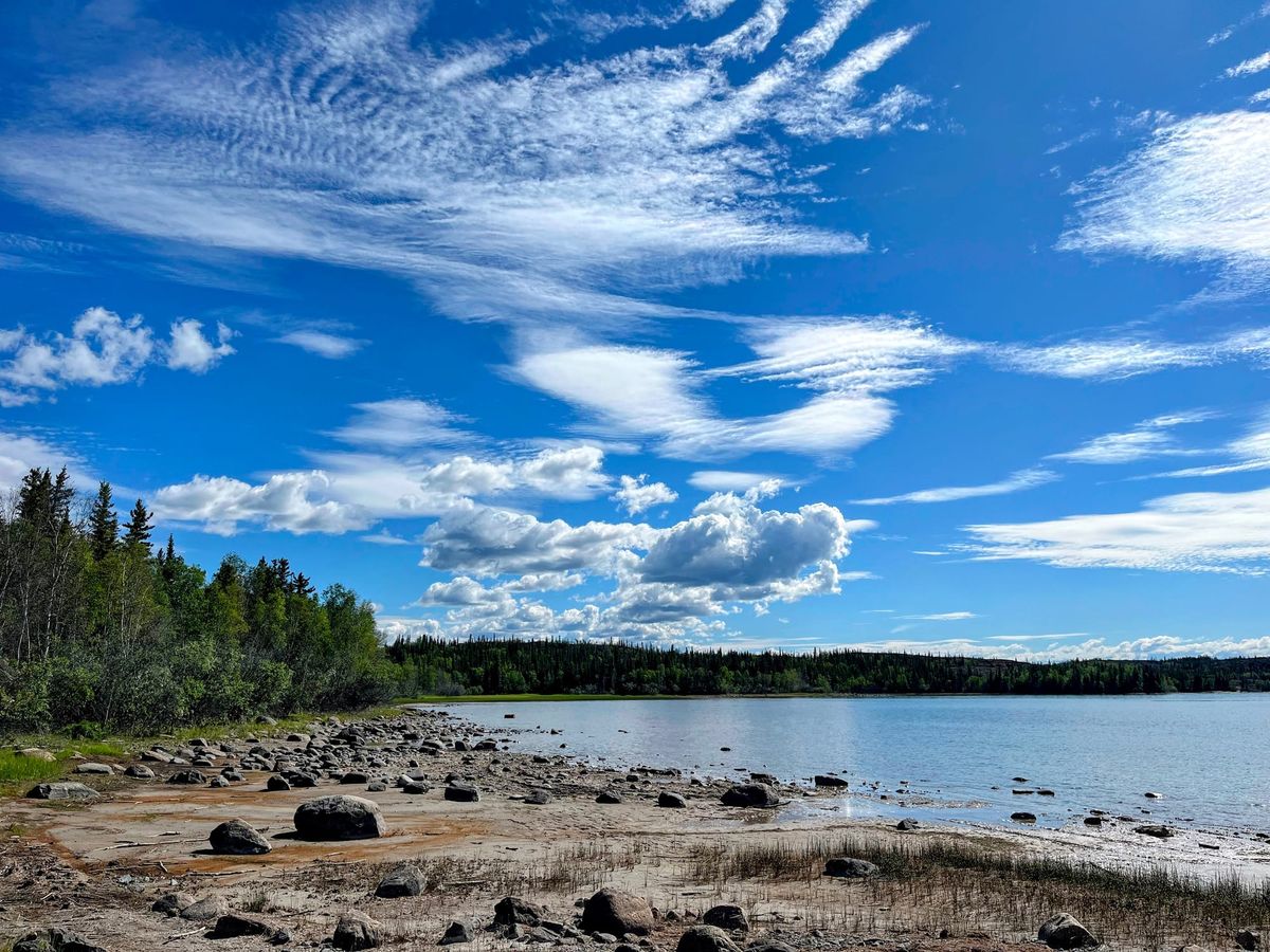 A lake lined with trees and a rocky shore.