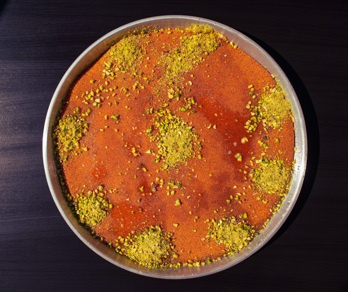 A cake in a metal pan sits in a table.