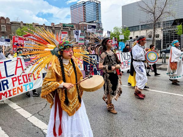 Protesters in Native regalia participate in a march.