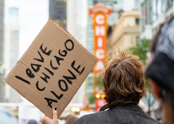 A person holding a sign that says, "Leave Chicago Alone."