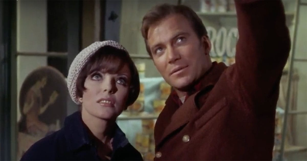 Captain Kirk and Edith Keeler stand together in "The City on the Edge of Forever," looking up at something in the distance.