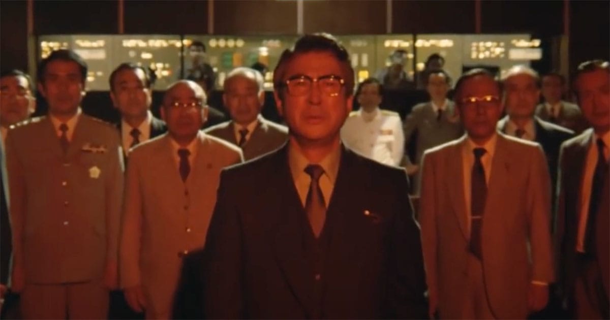 Prime Minister and officials stand in tense silence in "The Return of Godzilla" as crisis unfolds.