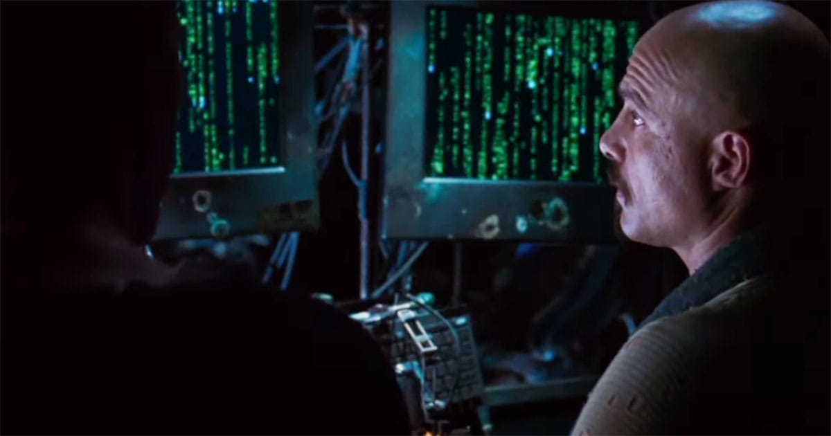 Cypher looks at Matrix code on monitors while contemplating betrayal in "The Matrix."