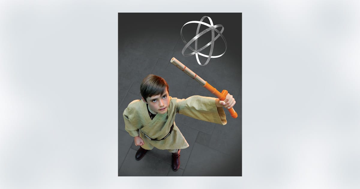 Child dressed as a Jedi Padawan practicing with a training droid and lightsaber.