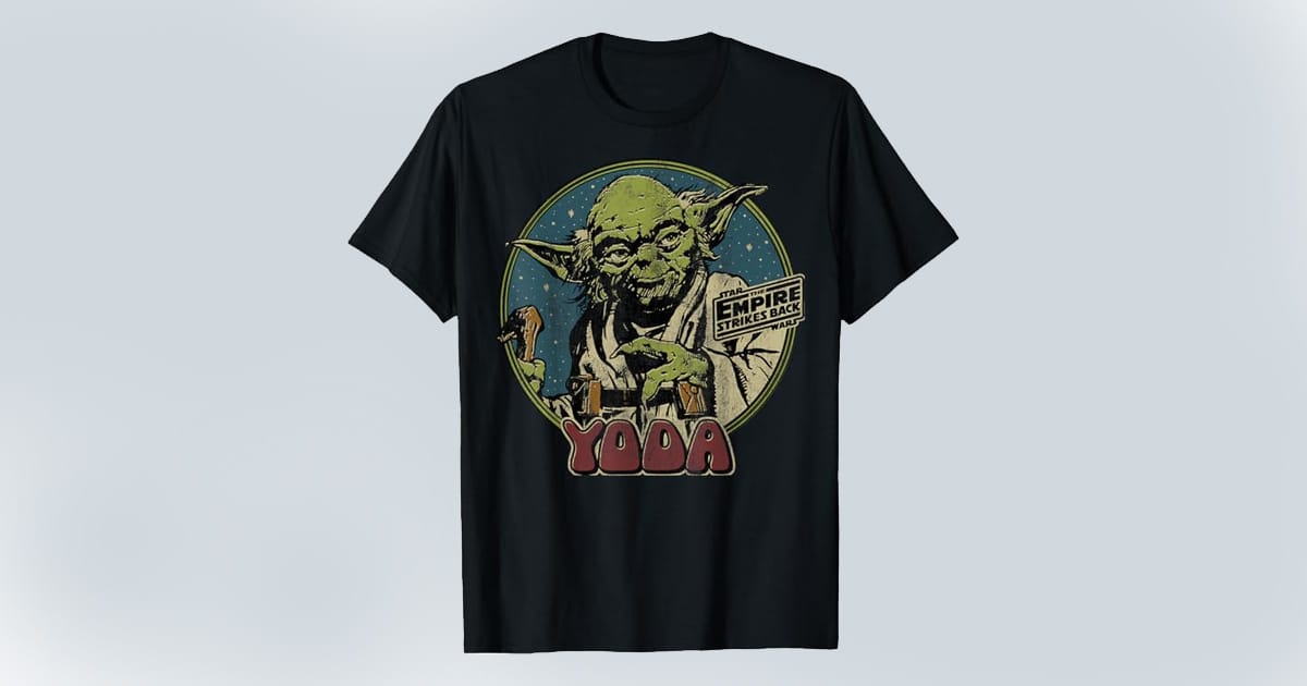 Black T-shirt featuring a vintage graphic of Yoda from "The Empire Strikes Back" with a circular starry background and bold retro lettering.