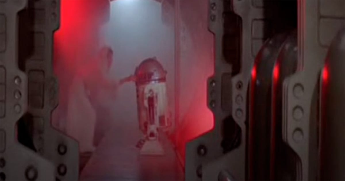 R2-D2 transporting Death Star plans aboard the Tantive IV amidst smoke and red emergency lighting.