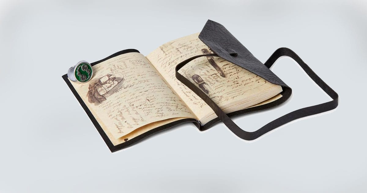 "Doctor Who" Journal of Impossible Things open to illustrated pages, shown with the Master’s ring.