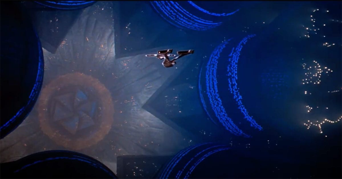 The USS Enterprise floats within the interior of V’Ger’s colossal structure, surrounded by glowing alien geometry.