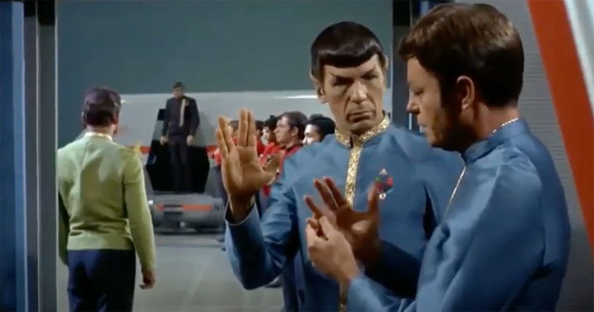 Spock showing Dr. McCoy how to perform the Vulcan salute in a scene from "Star Trek."
