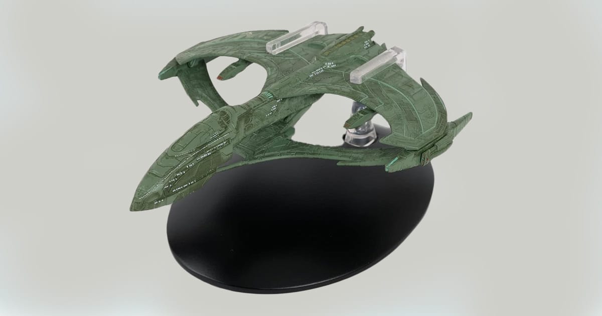 Aelahl-class Romulan Light Warbird replica model on display stand, showcasing green clamshell hull and elongated structure.