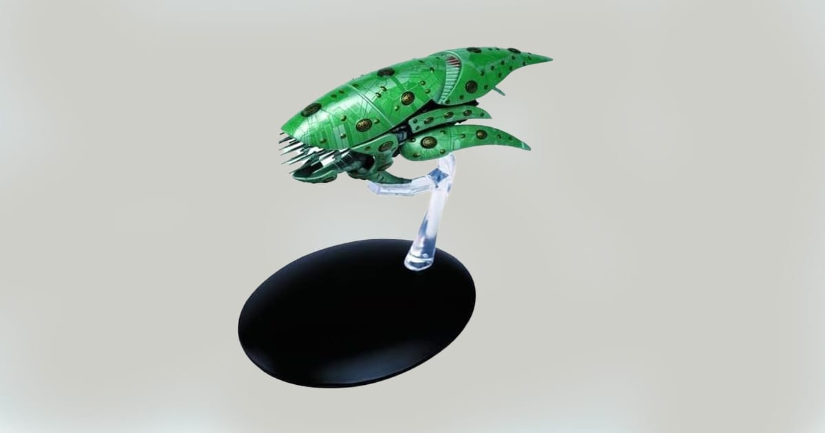 Romulan Drone starship replica on display stand featuring green armored hull and spiked front section.