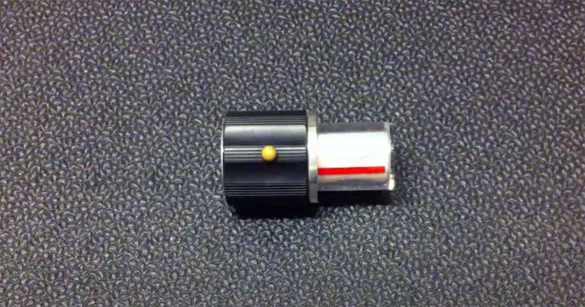 Close-up of a black and silver "Star Trek" control knob prop with red and yellow detailing used in various episodes.