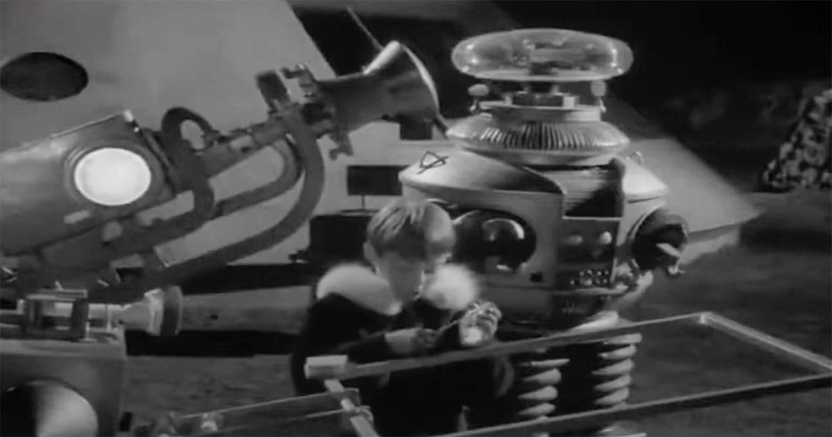 Will Robinson and the Robot from "Lost in Space" working with equipment on an alien world, representing cooperation and optimism in science fiction.