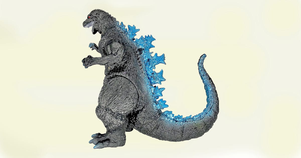 Classic Godzilla action figure in dark gray with bright blue dorsal spines, posed in side profile with curved tail.