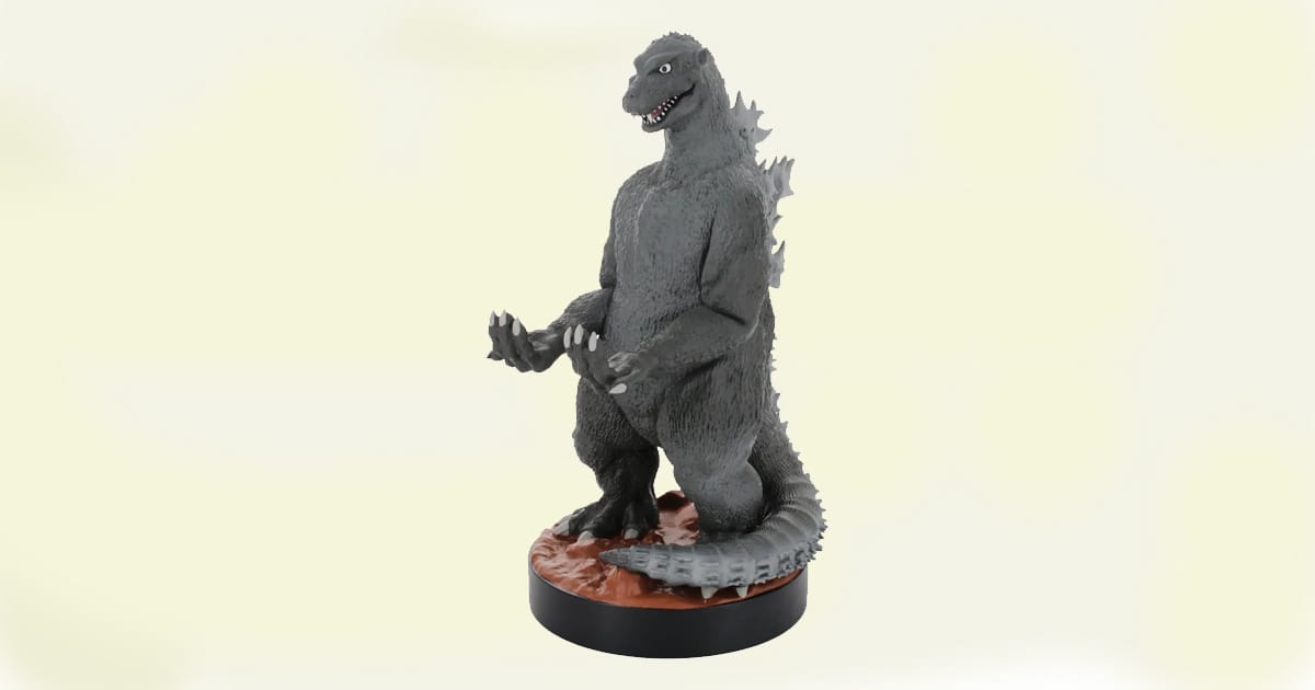 Vintage-style Godzilla figure standing upright on a round base with gray skin and sculpted dorsal plates.