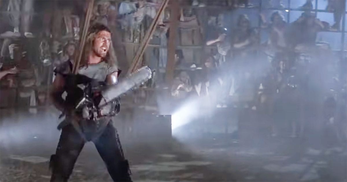 Max Rockatansky stands armed inside the Thunderdome arena surrounded by spectators in a pivotal scene from Mad Max Beyond Thunderdome.