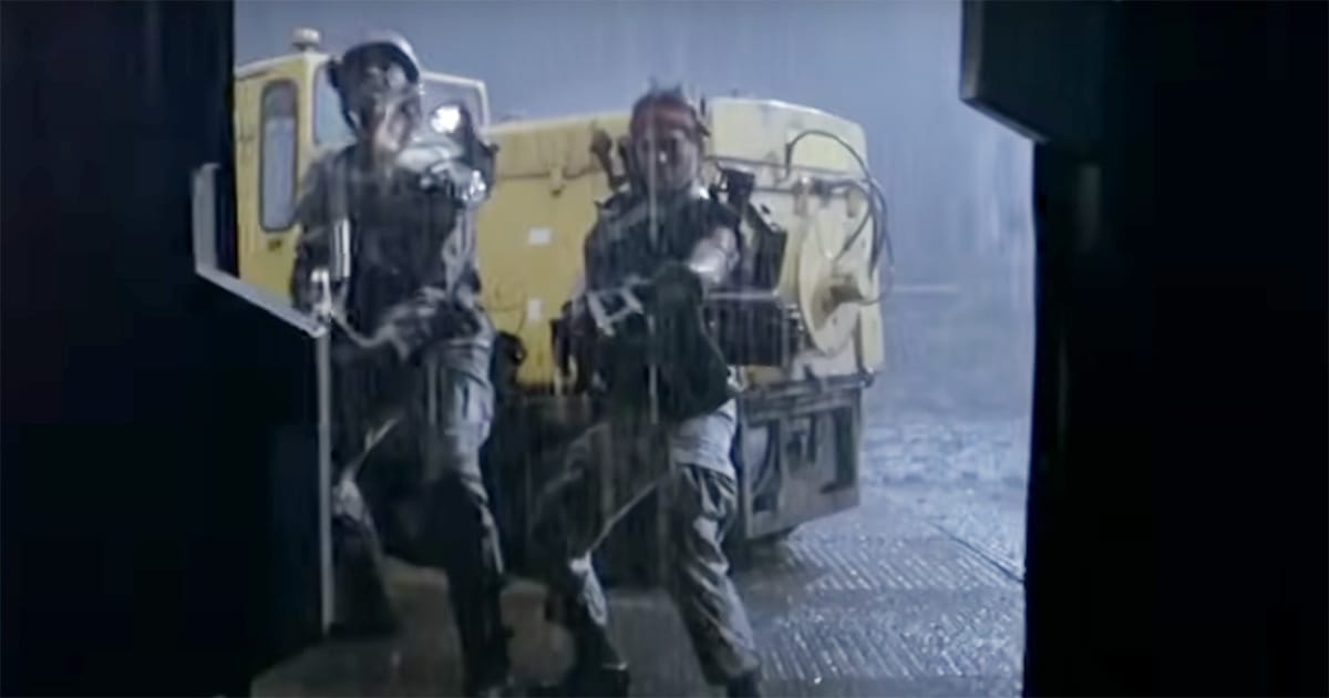 Colonial Marines entering Hadley’s Hope in the rain during Aliens 1986 with weapons ready at the doorway.