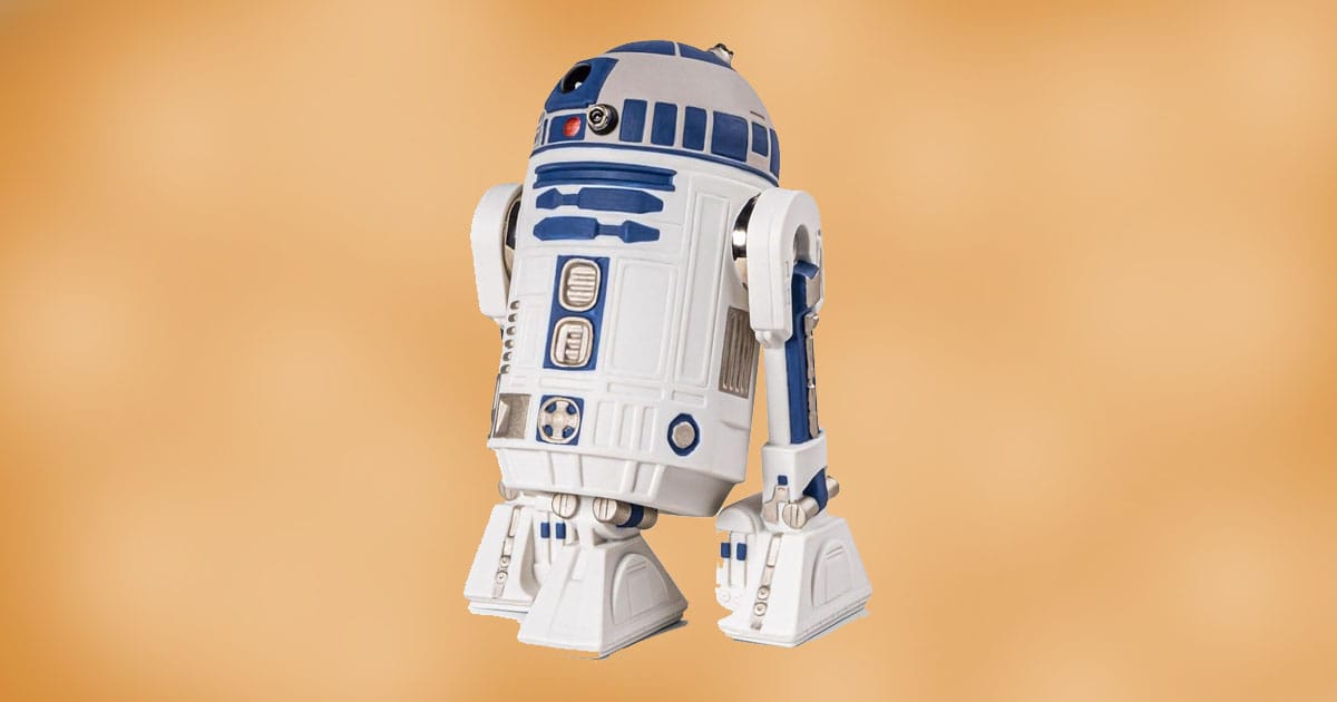 Porcelain R2-D2 collectible figure with white and blue detailing displayed against a warm background.