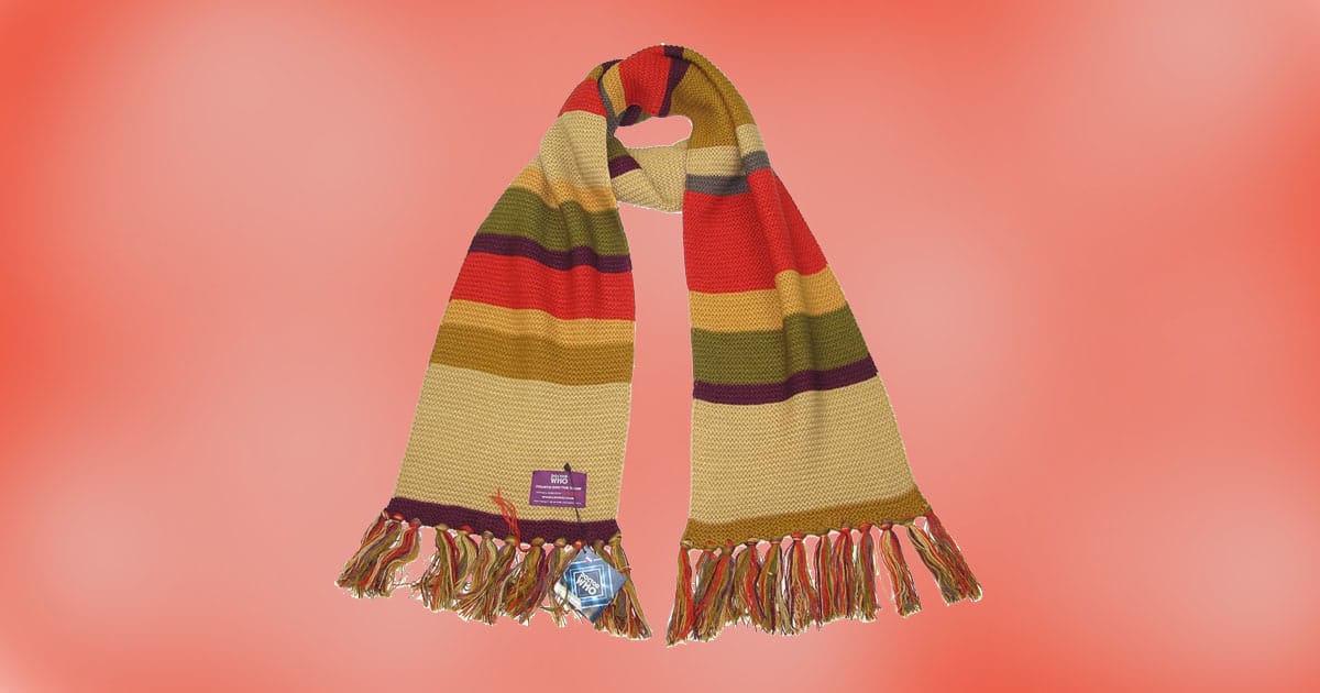 Doctor Who Fourth Doctor shorter scarf by LOVARZI, featuring multicolored stripes and fringed ends, displayed against a red background.