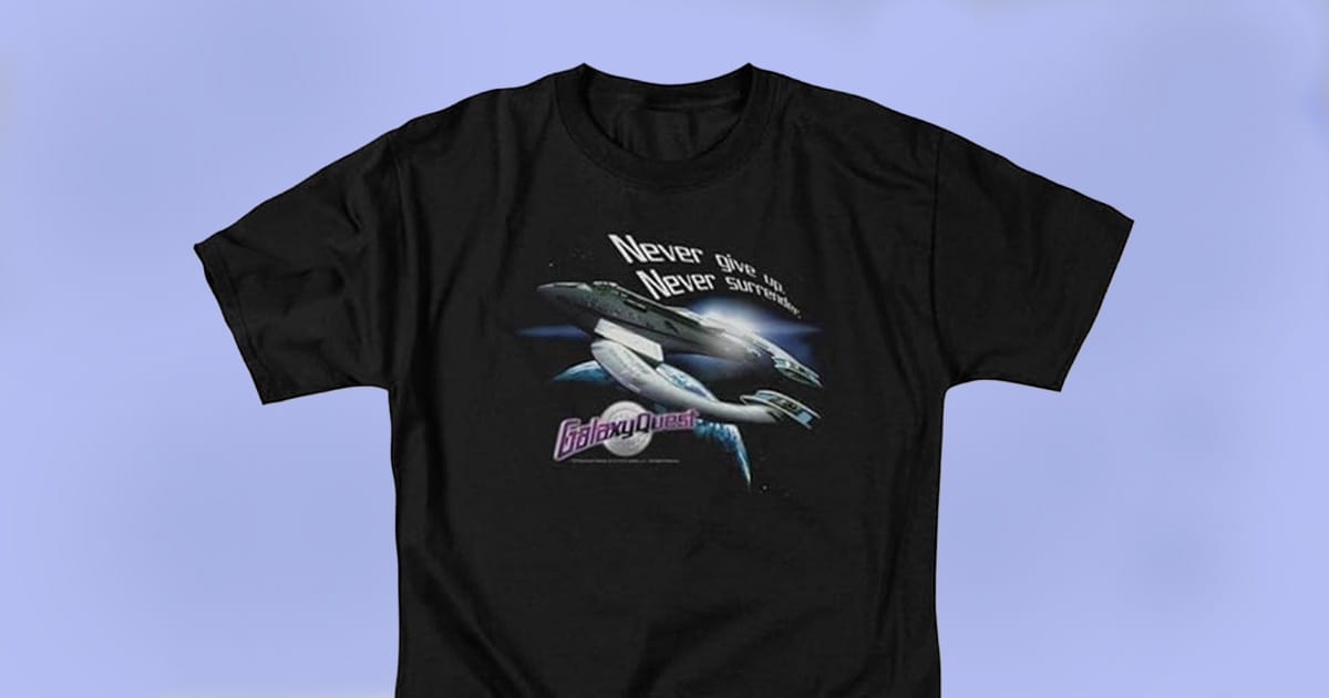 Black Galaxy Quest T-shirt with N.S.E.A. Protector spaceship and “Never Give Up Never Surrender” slogan