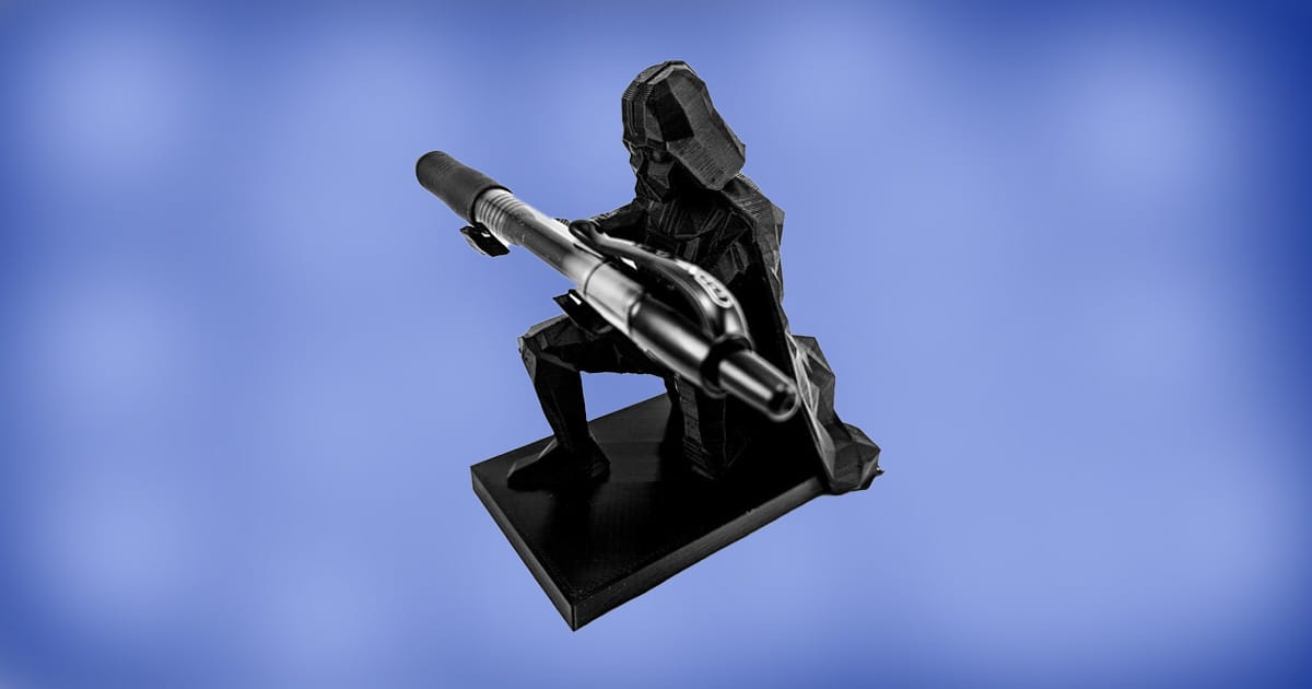 3D printed Darth Vader pen holder kneeling and holding a pen on a blue background.