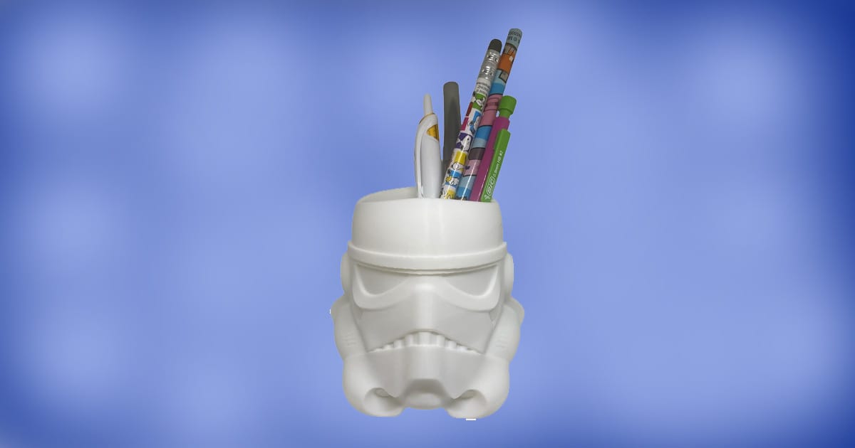 Star Wars Stormtrooper helmet pen and pencil holder filled with colorful pencils and pens on a blue background.