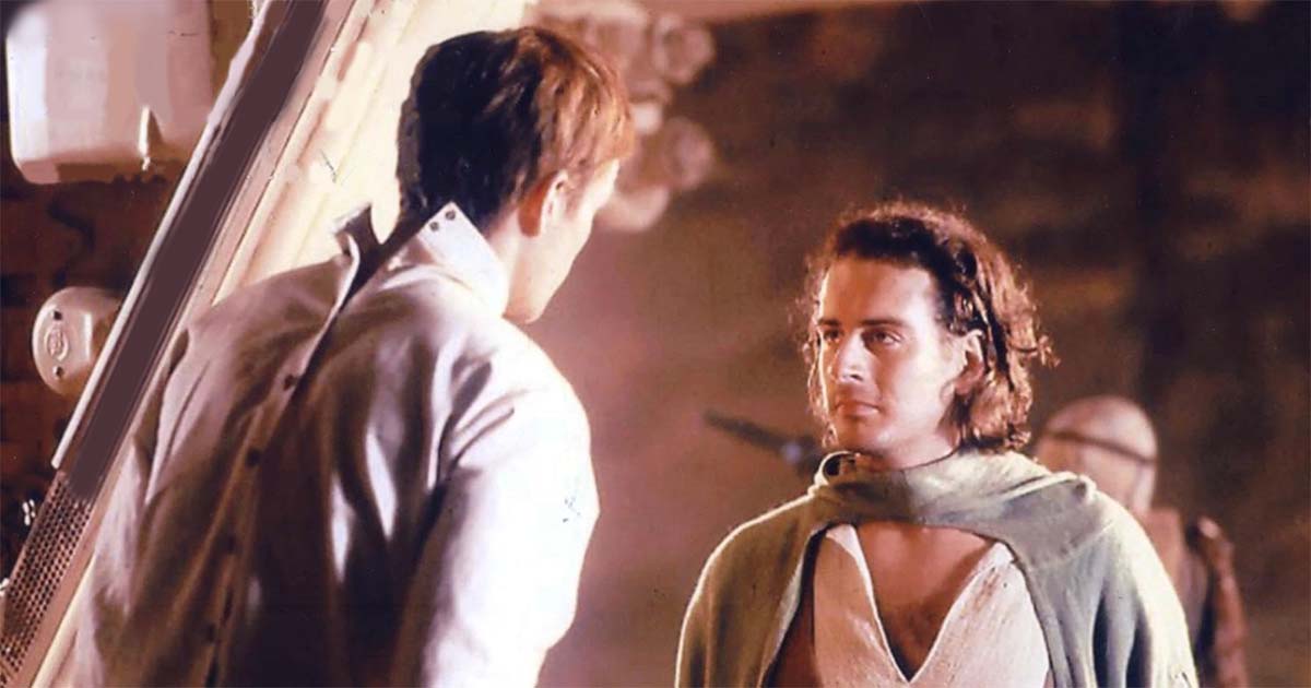 Two men speak in a warm-lit chamber on Arrakis, their faces marked by loyalty and the weight of coming war.