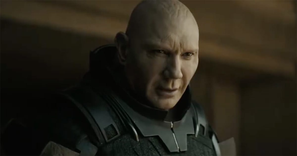 Dave Bautista as Glossu Rabban in Dune Part Two (2024) looking upward under dim light, face marked by tension and regret