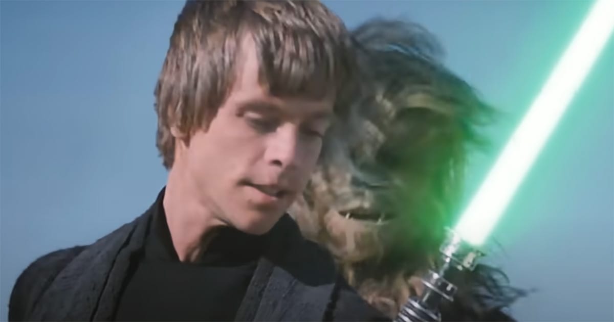 Luke Skywalker holding a green lightsaber beside Chewbacca on a desert skiff under a clear sky.