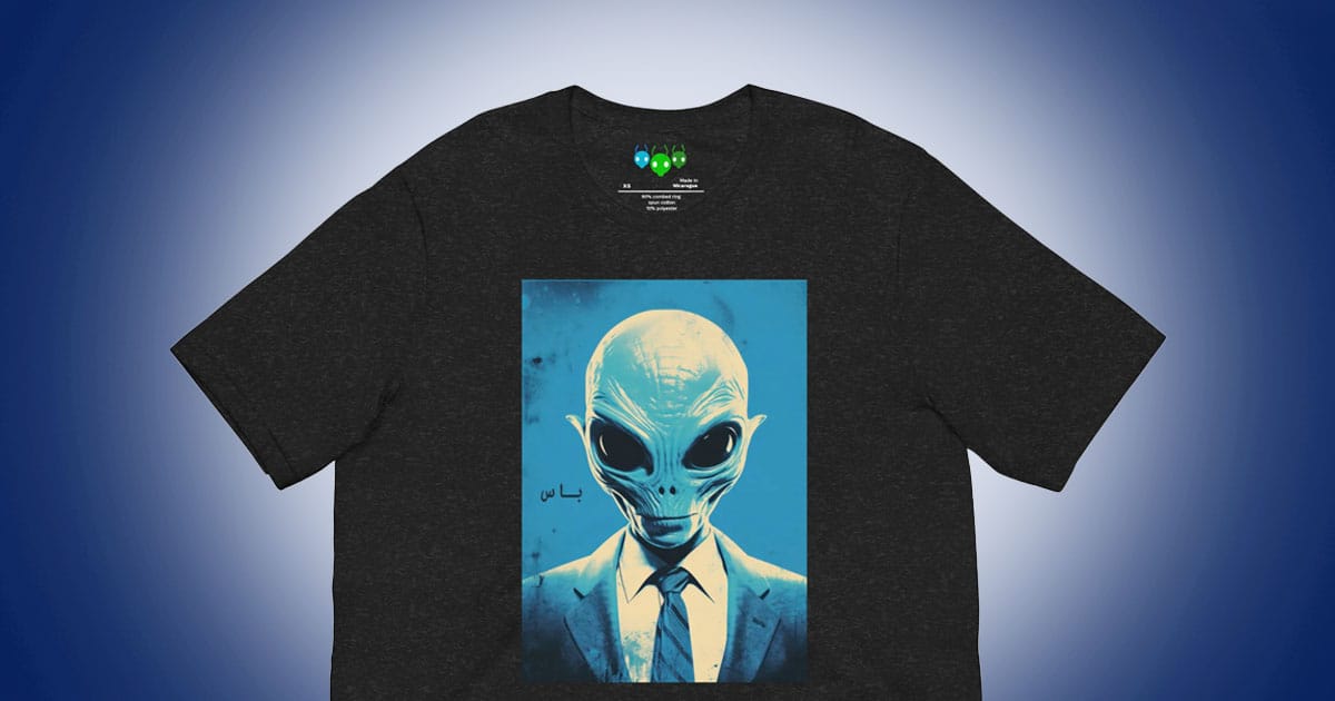 Graphic T-shirt featuring a blue alien in a suit with large black eyes against a bright background
