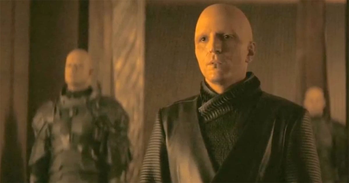 David Dastmalchian as Piter de Vries, hands clasped in a vast metallic hall, the modern vision of thought without compassion.