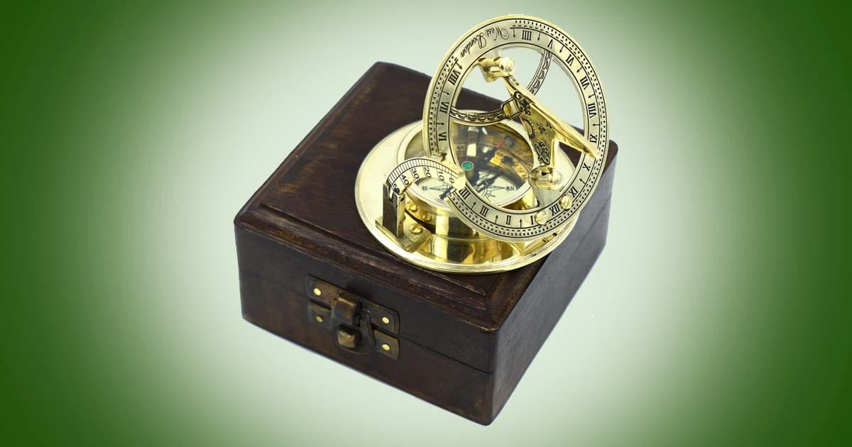 Antique brass sundial compass on wooden box, vintage nautical timepiece and navigation collectible inspired by classic exploration and science fiction adventure.