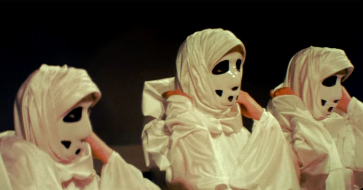Masked figures dressed in white robes representing conformity and loss of identity in the 1976 science fiction film Logan’s Run.