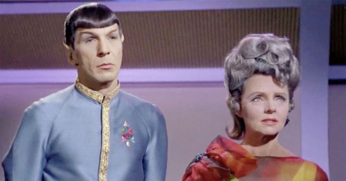Spock standing beside his mother Amanda Grayson aboard a starship interior, both composed and reserved, reflecting emotional restraint in Star Trek.